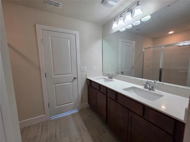 a bathroom with a double vanity sink and a mirror