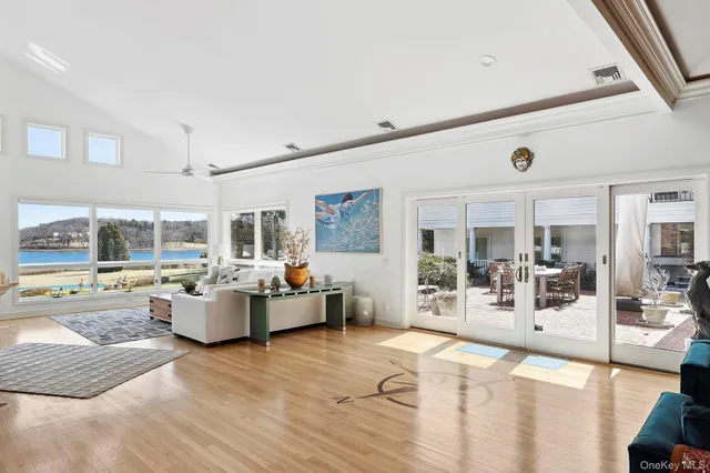 a living room with furniture large window and kitchen view