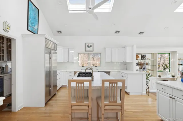 a kitchen with stainless steel appliances kitchen island granite countertop a refrigerator and cabinets