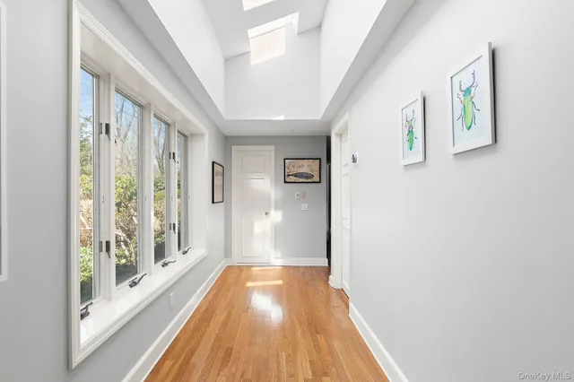 a view of a hallway with wooden floor and windows