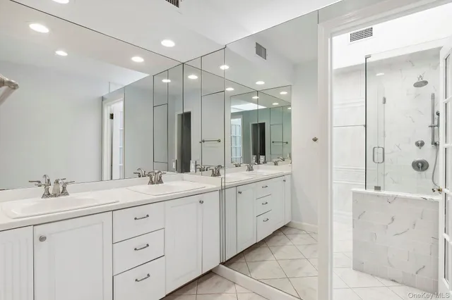 a spacious bathroom with a double vanity sink mirror and double