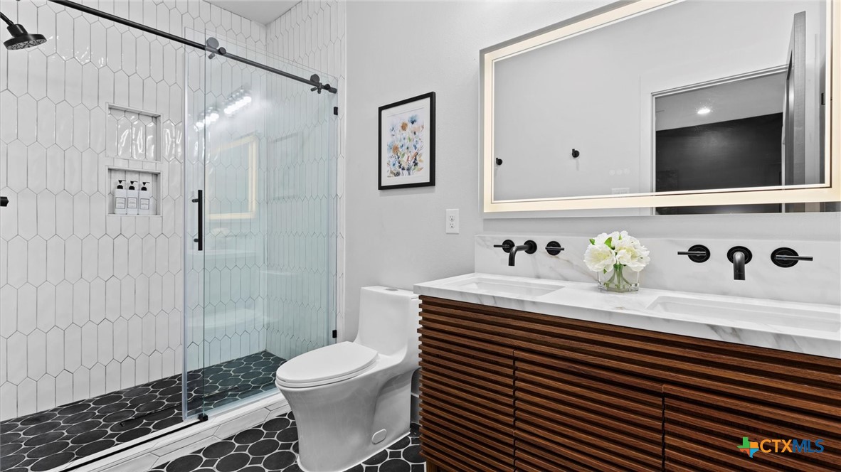 6786 River Road New Braunfels, TX 78132 - Photo 20 of 38 a bathroom with a sink a toilet and shower