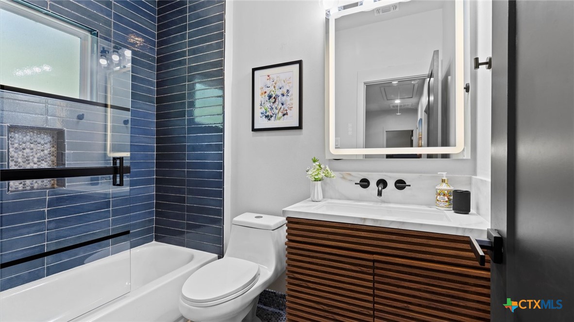 6786 River Road New Braunfels, TX 78132 - Photo 25 of 38 a bathroom with a sink toilet and mirror