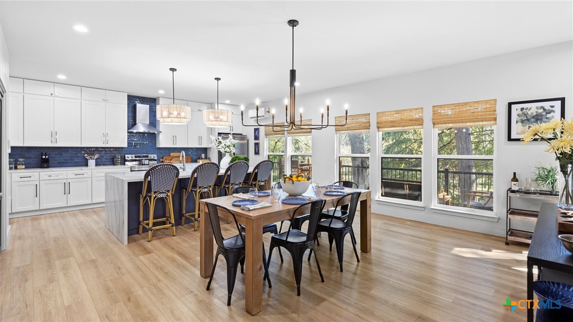 6786 River Road New Braunfels, TX 78132 - Photo 5 of 38 a view of a dining room and livingroom with furniture wooden floor a chandelier