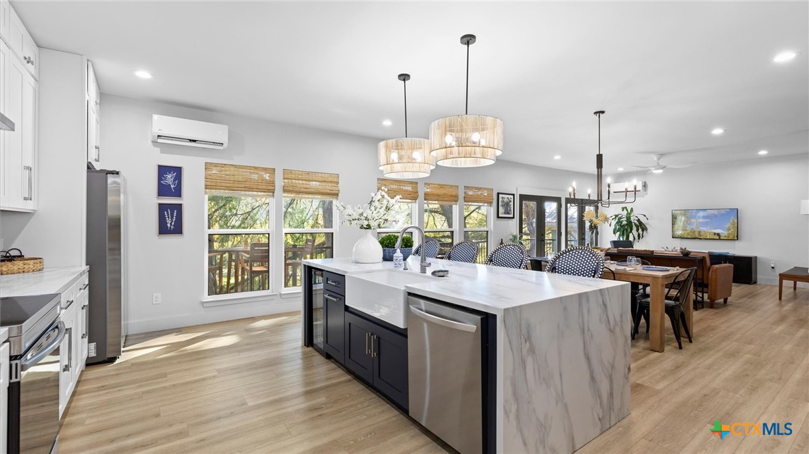 6786 River Road New Braunfels, TX 78132 - Photo 8 of 38 a view of counter top space with kitchen island stainless steel appliances furniture wooden floor and a chandelier
