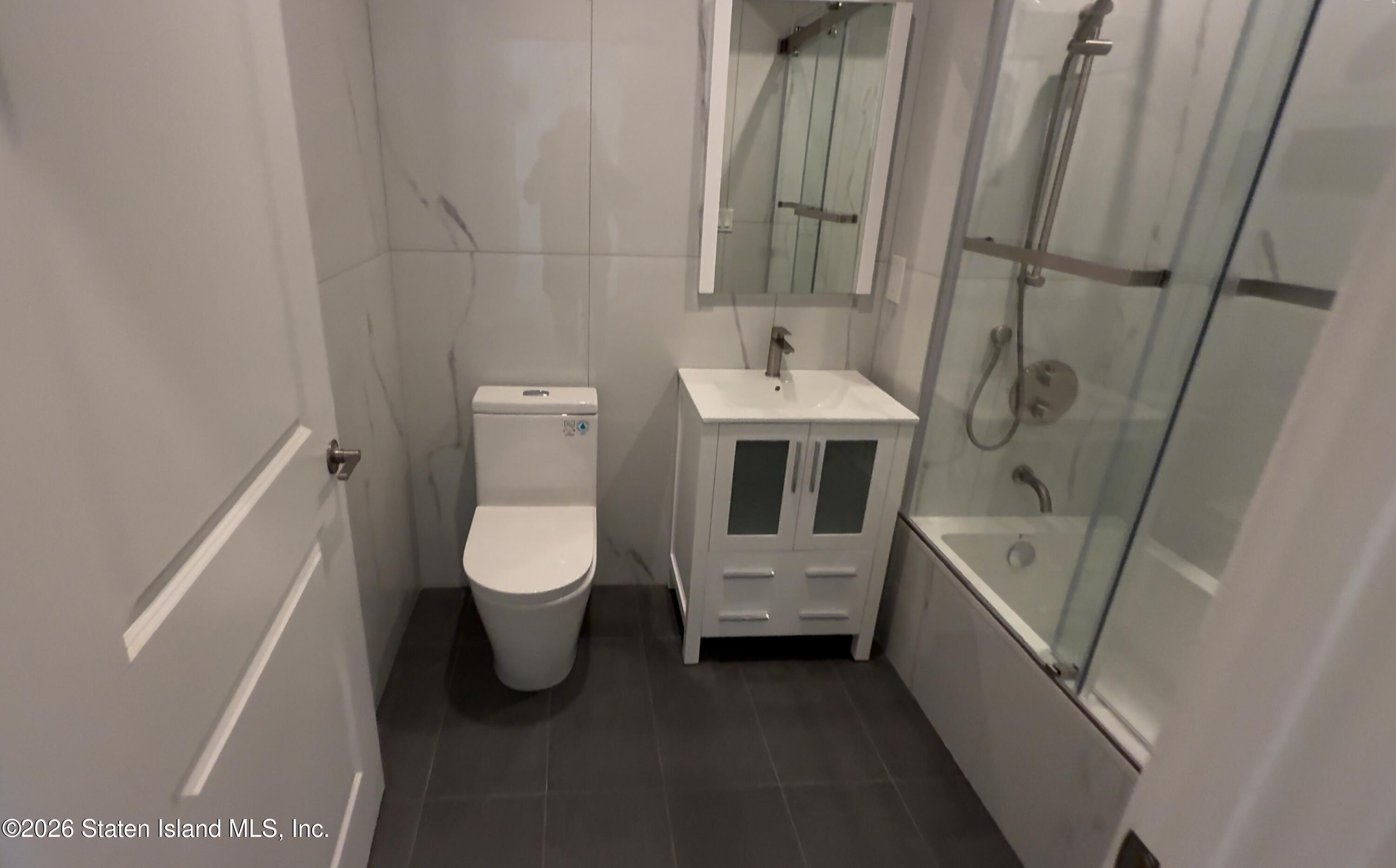 1239 Forest Hill Road, Unit 7 Staten Island, NY 10314 - Photo 13 of 14 a bathroom with a toilet sink and mirror