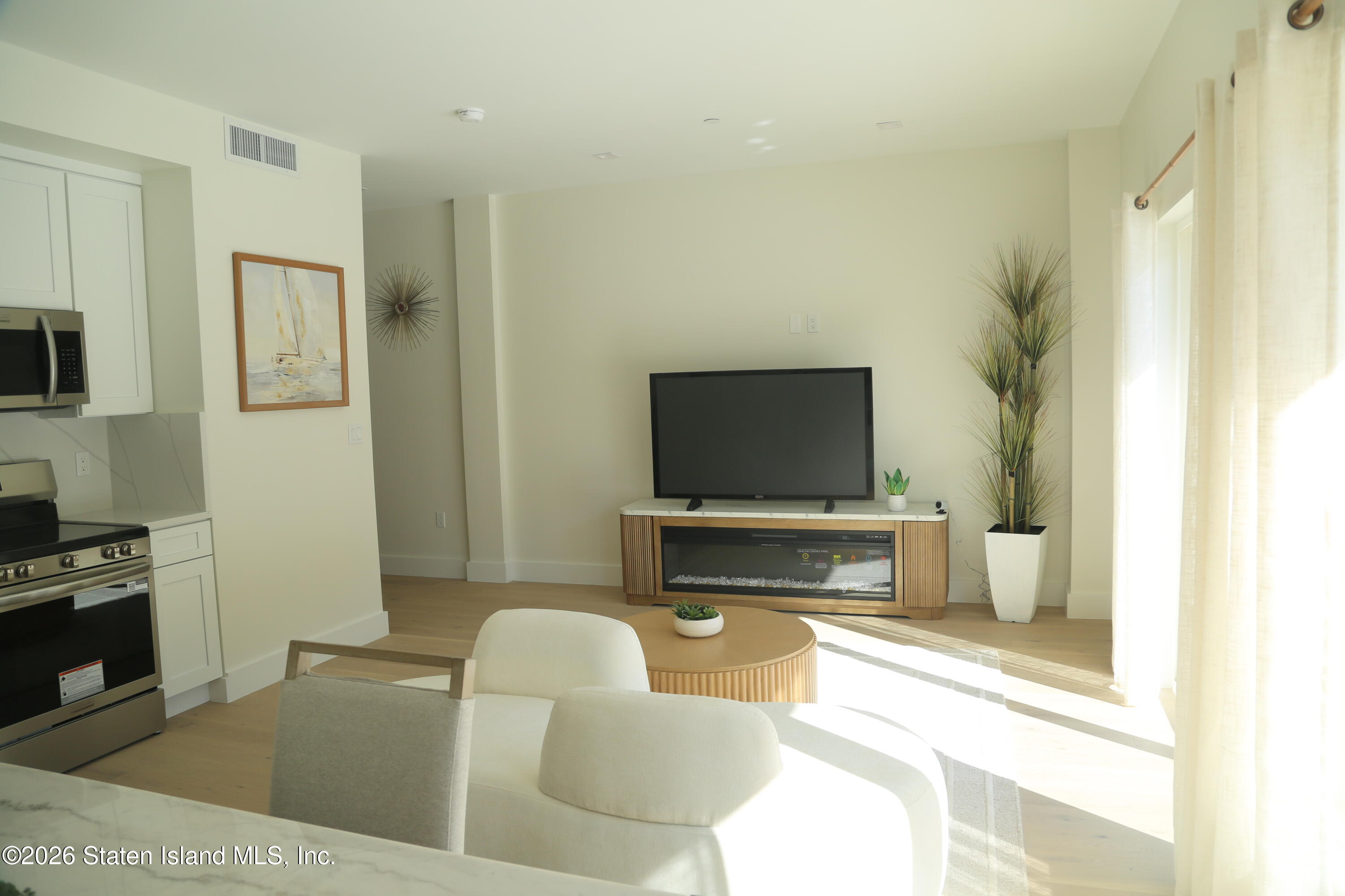1239 Forest Hill Road, Unit 7 Staten Island, NY 10314 - Photo 7 of 14 a living room with furniture and a flat screen tv
