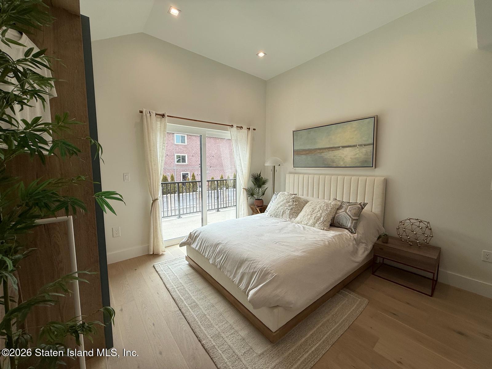 1239 Forest Hill Road, Unit 7 Staten Island, NY 10314 - Photo 10 of 14 a bedroom with a large bed and a potted plant