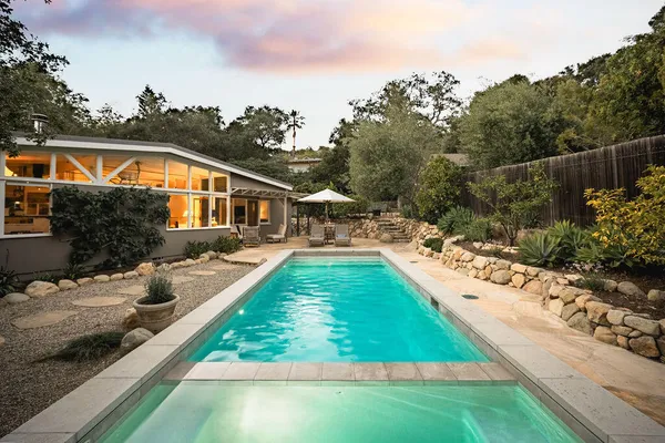 a view of a house with backyard and sitting area