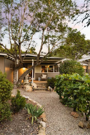a view of a house with a tree in the yard