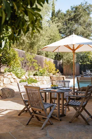 a backyard of a house with table and chairs