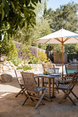 a backyard of a house with table and chairs