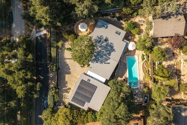 a view of a white house with a yard and potted plants