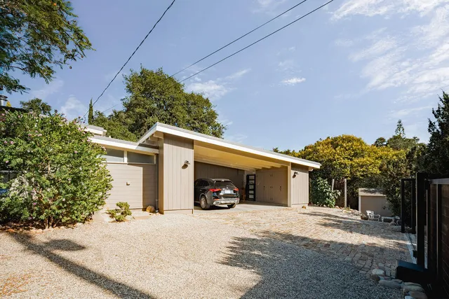 a front view of a house with a tree