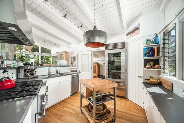 a kitchen with stainless steel appliances granite countertop a stove a sink dishwasher and cabinets with wooden floor