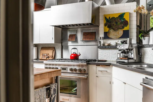 a kitchen with stainless steel appliances granite countertop a stove and a microwave
