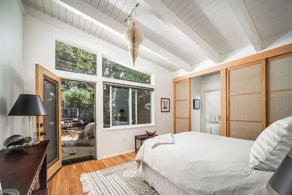 a bedroom with a bed and a large window with the outer view