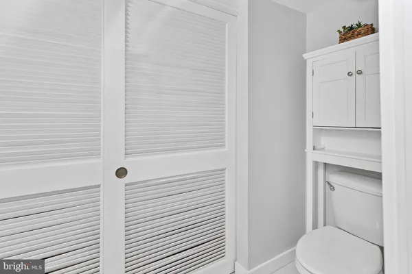 a white toilet sitting next to a shower