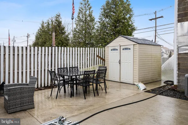 a view of a patio with a table and chairs with wooden fence