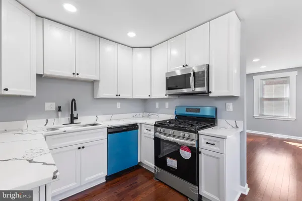 a kitchen with stainless steel appliances granite countertop a stove a sink and a microwave