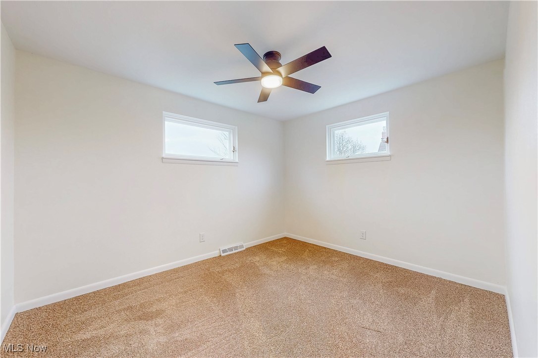 1723 Bantam Ridge Road Steubenville, OH 43953 - Photo 15 of 22 Spare room featuring visible vents, ceiling fan, light carpet, and baseboards