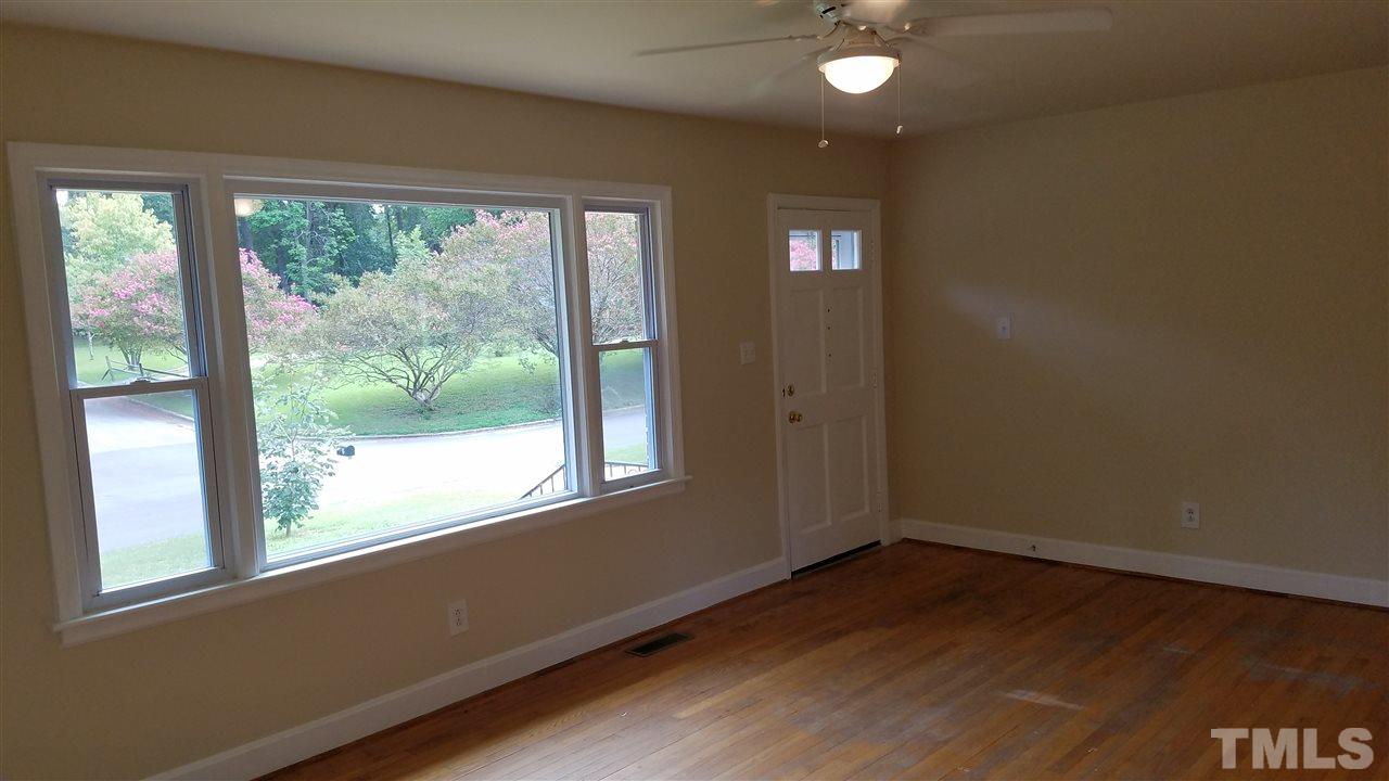 3616 Woodside Road Garner, NC 27529 - Photo 4 of 11 an empty room with wooden floor and windows