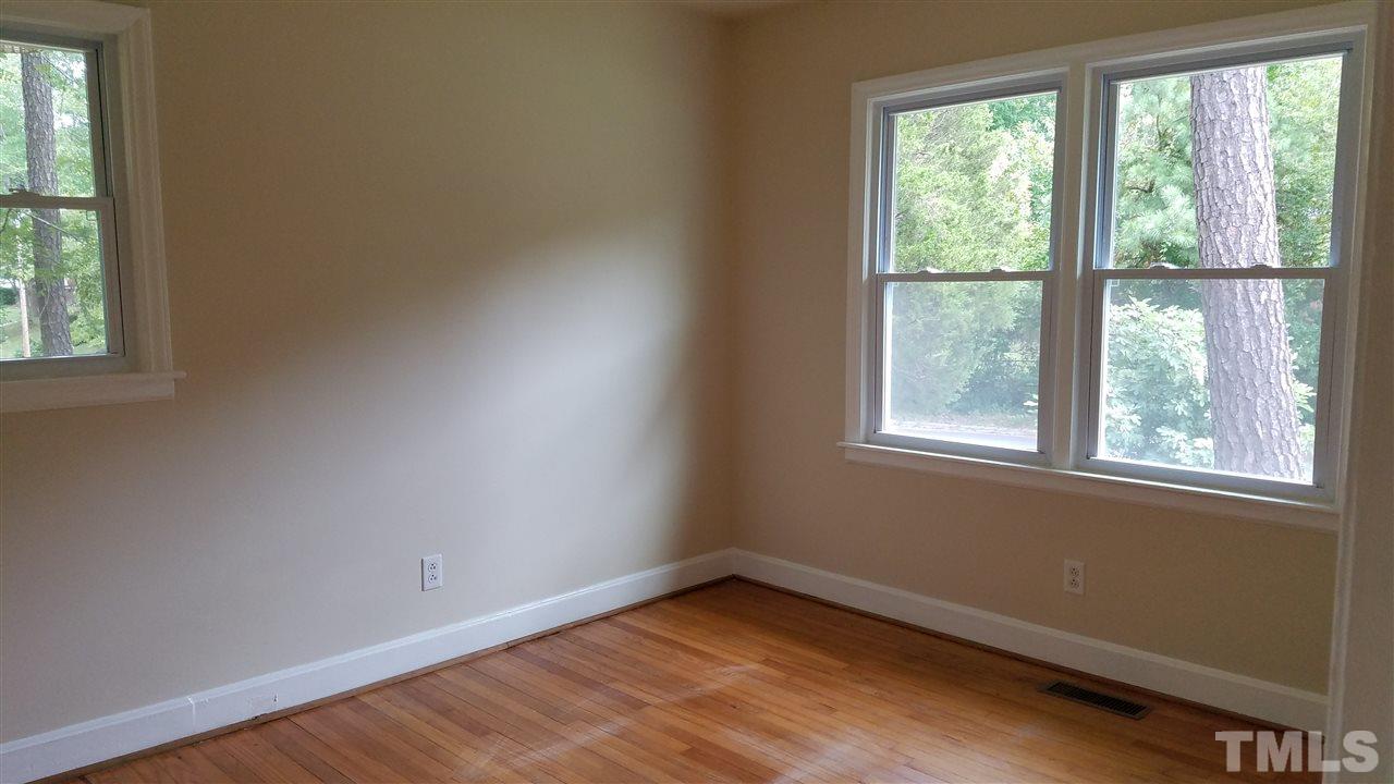 3616 Woodside Road Garner, NC 27529 - Photo 6 of 11 an empty room with wooden floor and windows