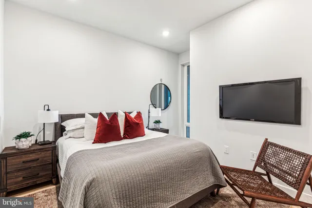 a bedroom with a bed and a flat screen tv