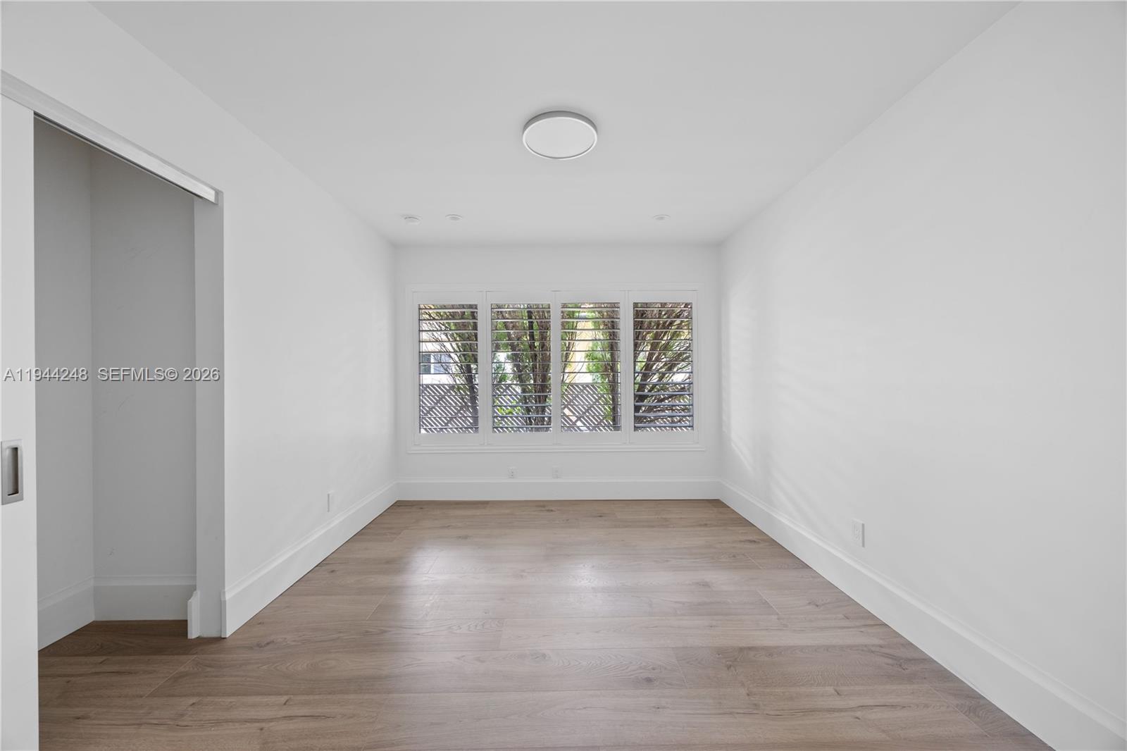 2530 Northeast 48th Street Lighthouse Point, FL 33064 - Photo 14 of 23 an empty room with wooden floor and windows