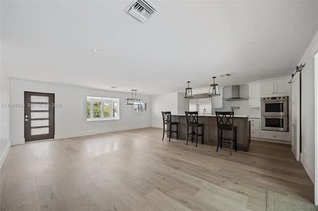 a view of a kitchen with dining room and wooden floor