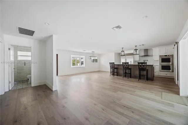a view of a kitchen with furniture and wooden floor