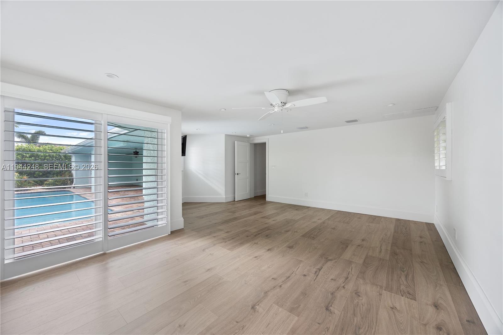 2530 Northeast 48th Street Lighthouse Point, FL 33064 - Photo 9 of 23 an empty room with wooden floor and windows