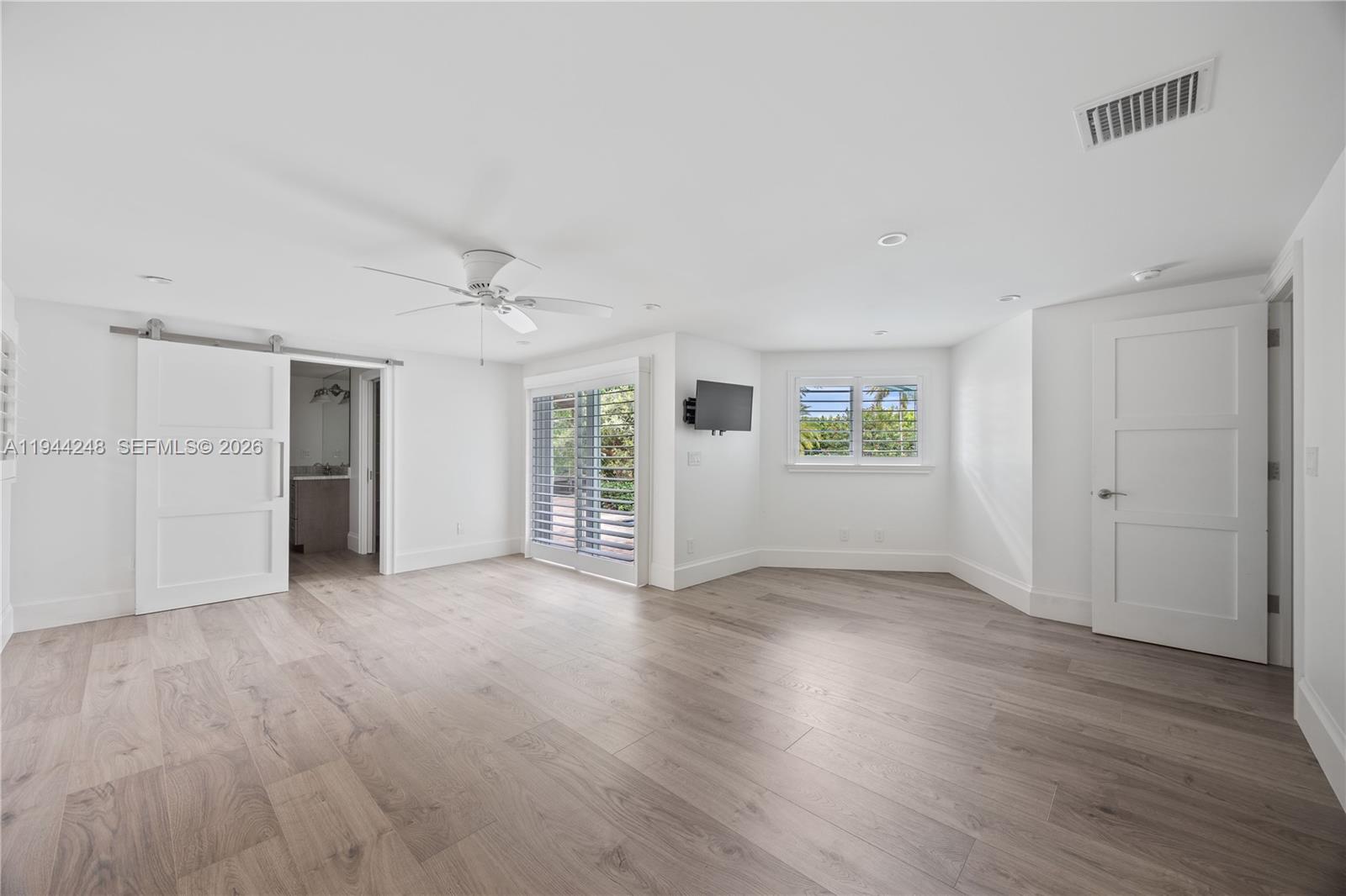 2530 Northeast 48th Street Lighthouse Point, FL 33064 - Photo 10 of 23 a view of an empty room with window and wooden floor