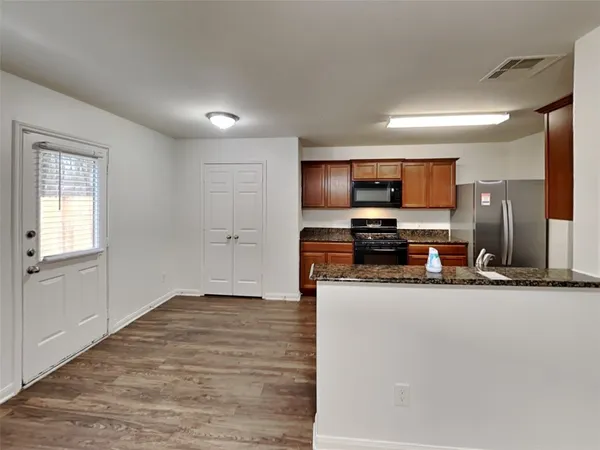 a view of empty room with wooden floor and windows