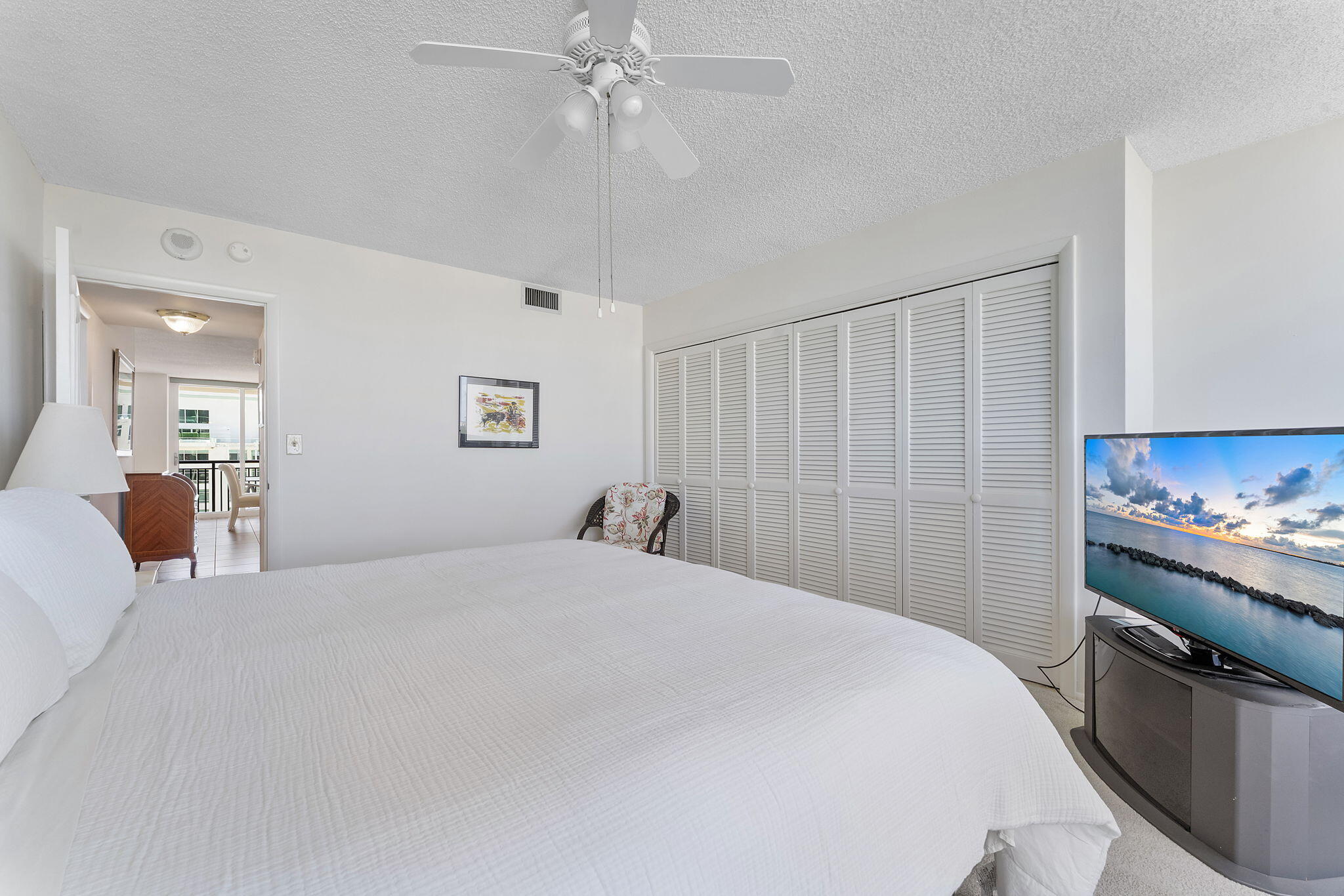 2000 South Ocean Boulevard, Unit 10H Boca Raton, FL 33432 - Photo 26 of 54 a bedroom with a bed and a chandelier