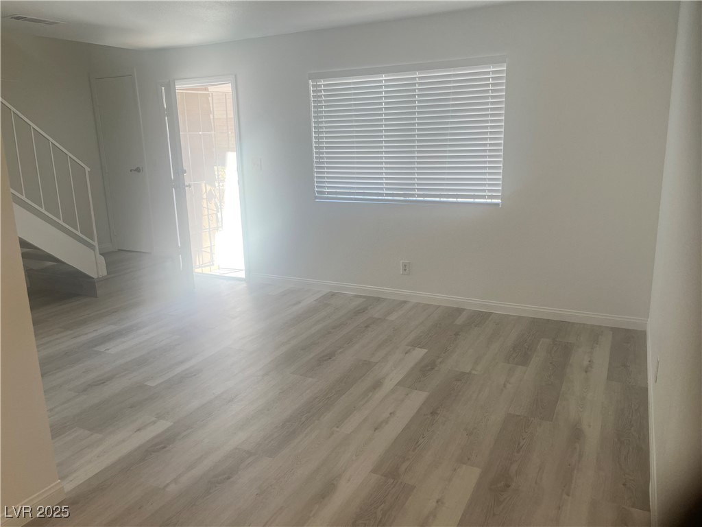 592 Sea Shell Lane Las Vegas, NV 89110 - Photo 12 of 24 Unfurnished room with light wood-style flooring and stairs