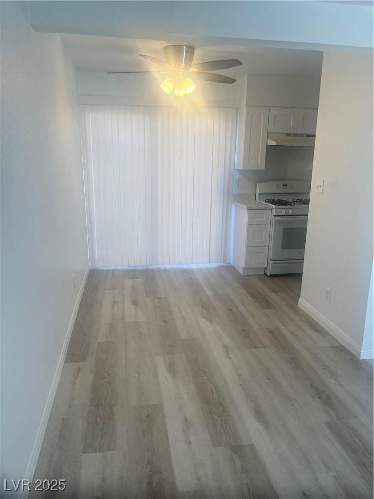 592 Sea Shell Lane Las Vegas, NV 89110 - Photo 3 of 24 Unfurnished dining area with light wood-type flooring and ceiling fan