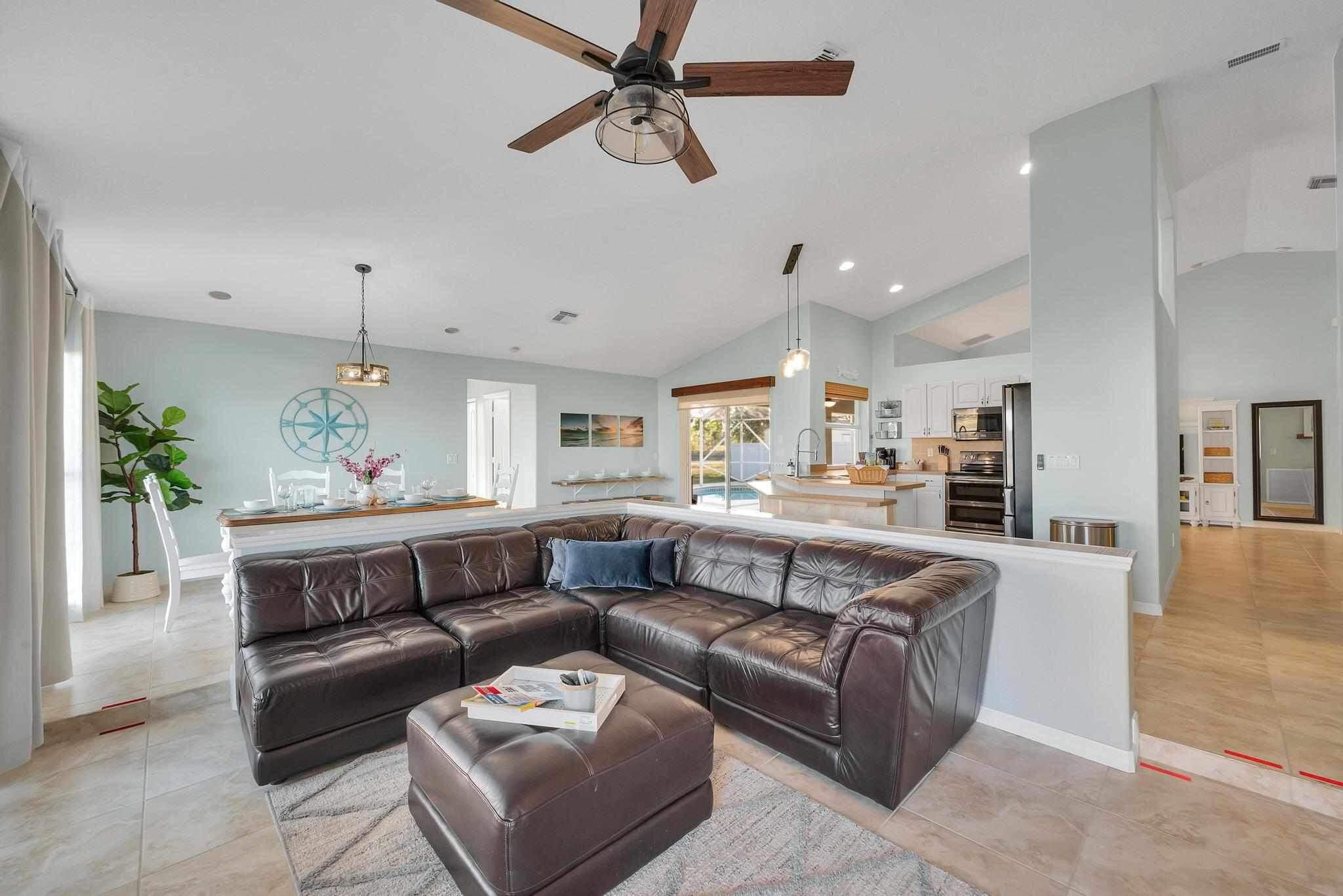 5464 Northwest Milner Drive Port St. Lucie, FL 34983 - Photo 12 of 49 a view of living room kitchen with furniture and a ceiling fan