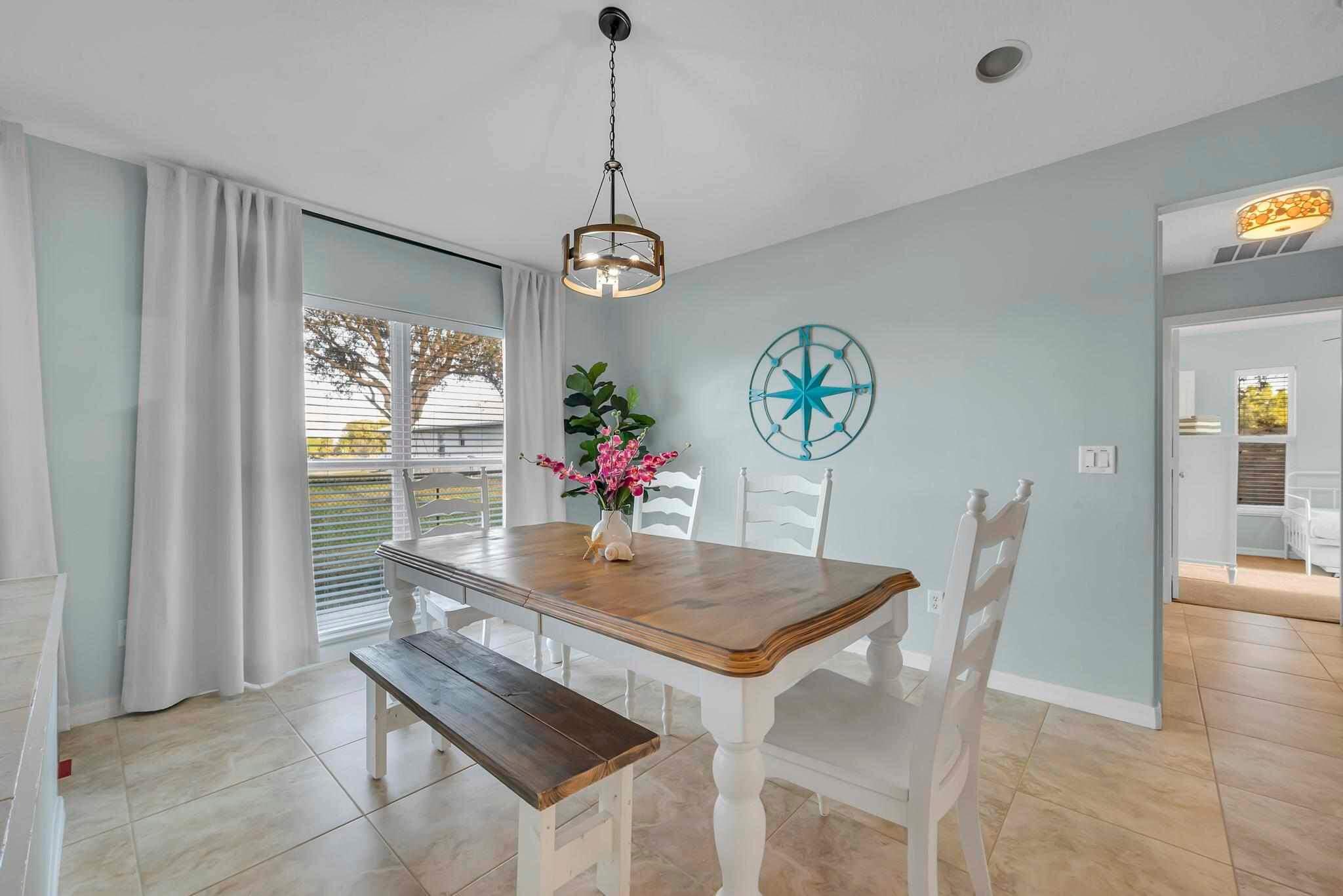 5464 Northwest Milner Drive Port St. Lucie, FL 34983 - Photo 17 of 49 a view of a dining room with furniture a chandelier and wooden floor