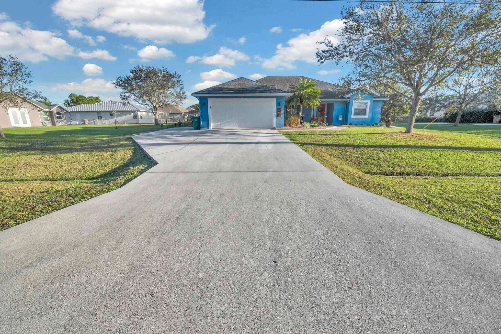 5464 Northwest Milner Drive Port St. Lucie, FL 34983 - Photo 2 of 49 a front view of a house with a yard