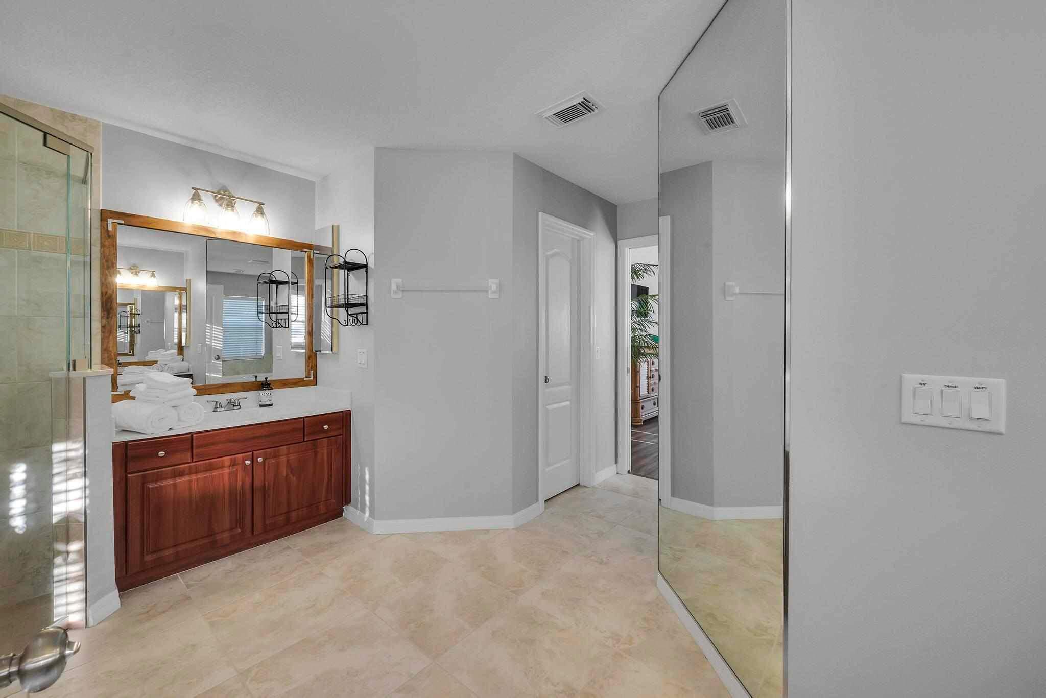 5464 Northwest Milner Drive Port St. Lucie, FL 34983 - Photo 26 of 49 a bathroom with a granite countertop sink mirror and shower