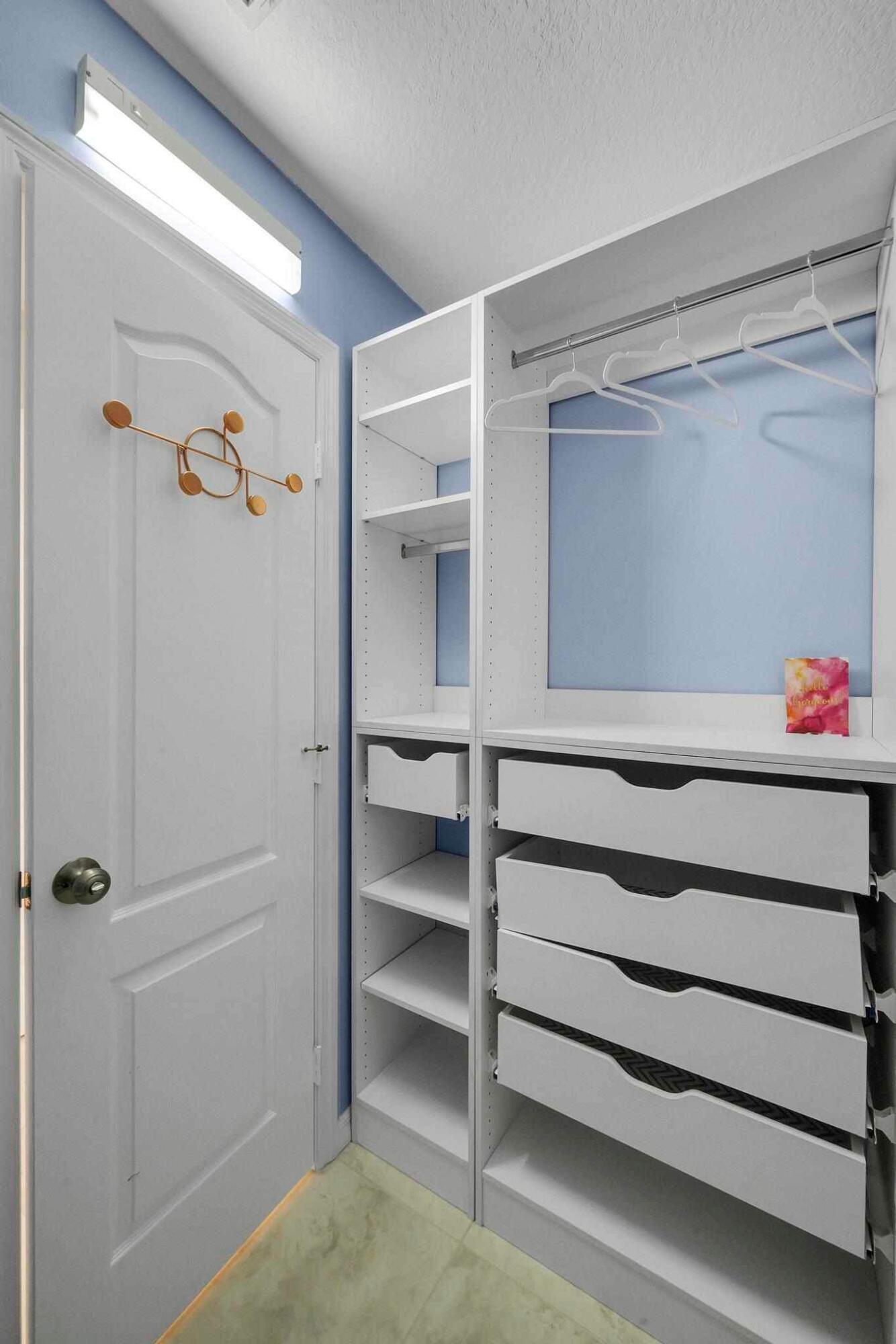 5464 Northwest Milner Drive Port St. Lucie, FL 34983 - Photo 27 of 49 a view of walk in closet with empty racks