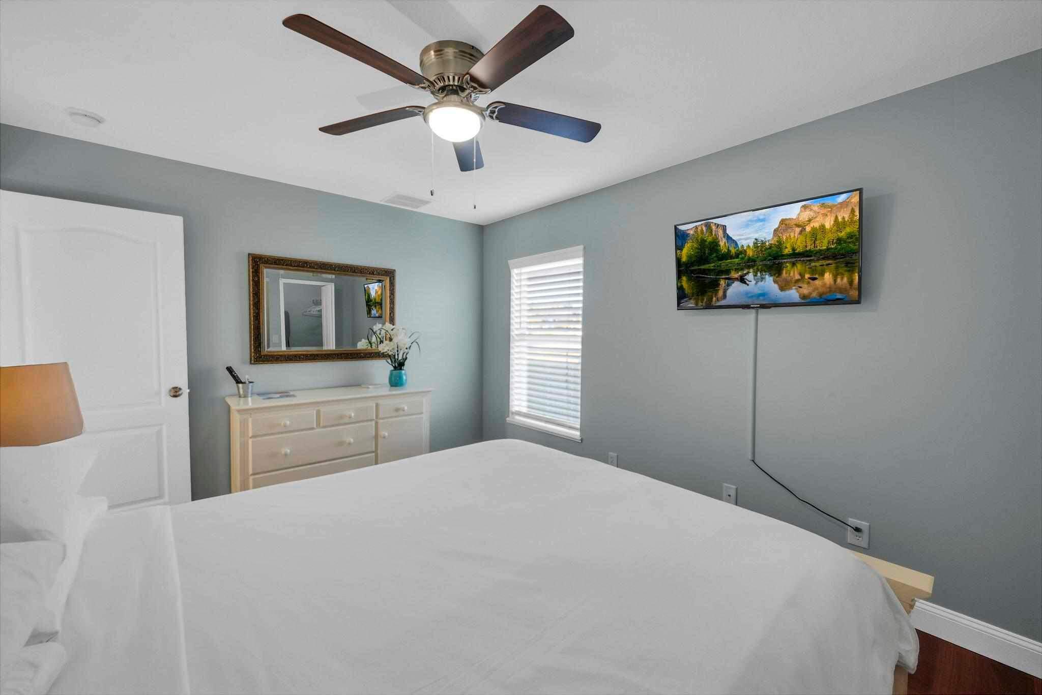 5464 Northwest Milner Drive Port St. Lucie, FL 34983 - Photo 31 of 49 a bedroom with a large bed a flat tv screen and dresser