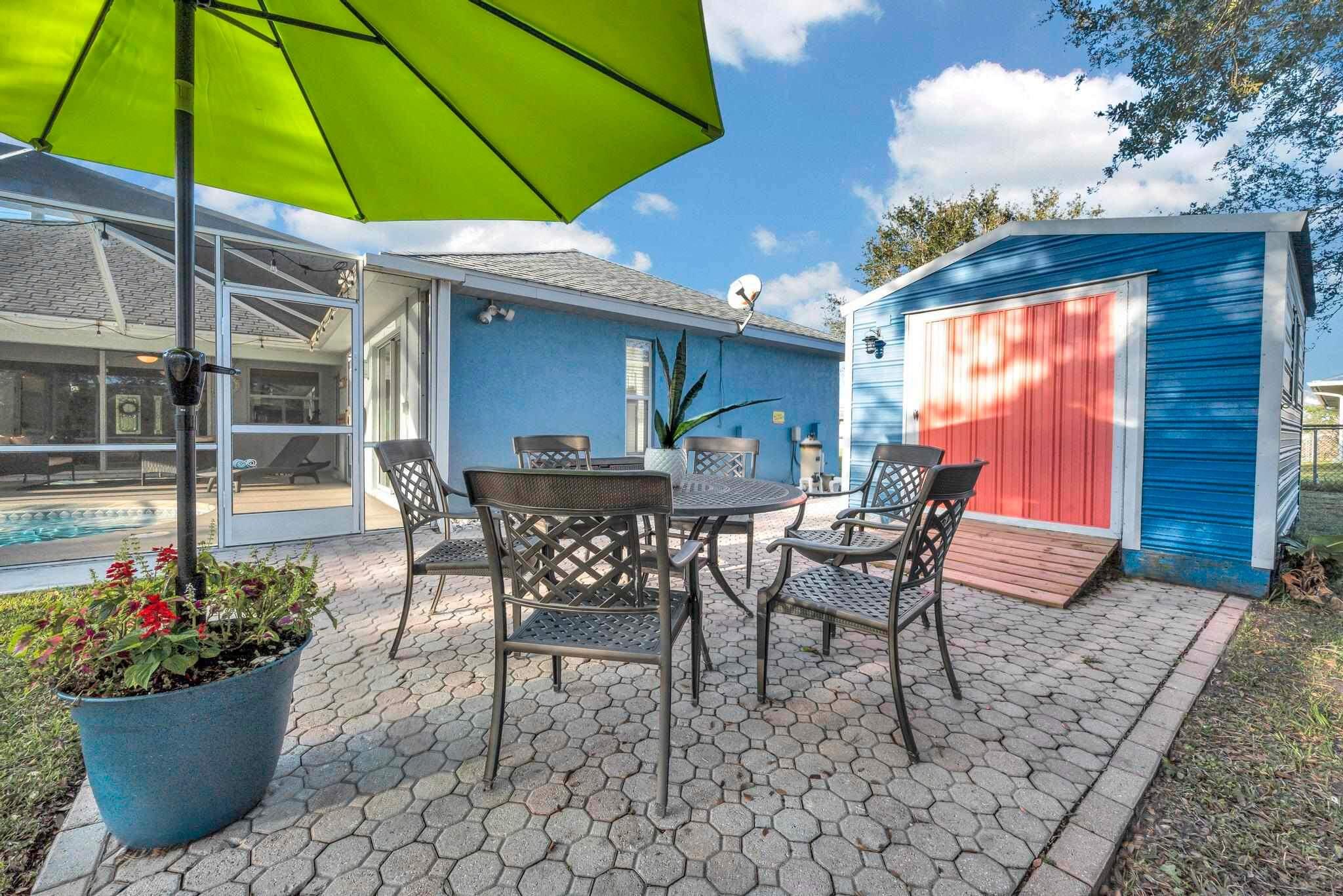 5464 Northwest Milner Drive Port St. Lucie, FL 34983 - Photo 45 of 49 a patio with a table and chairs under an umbrella