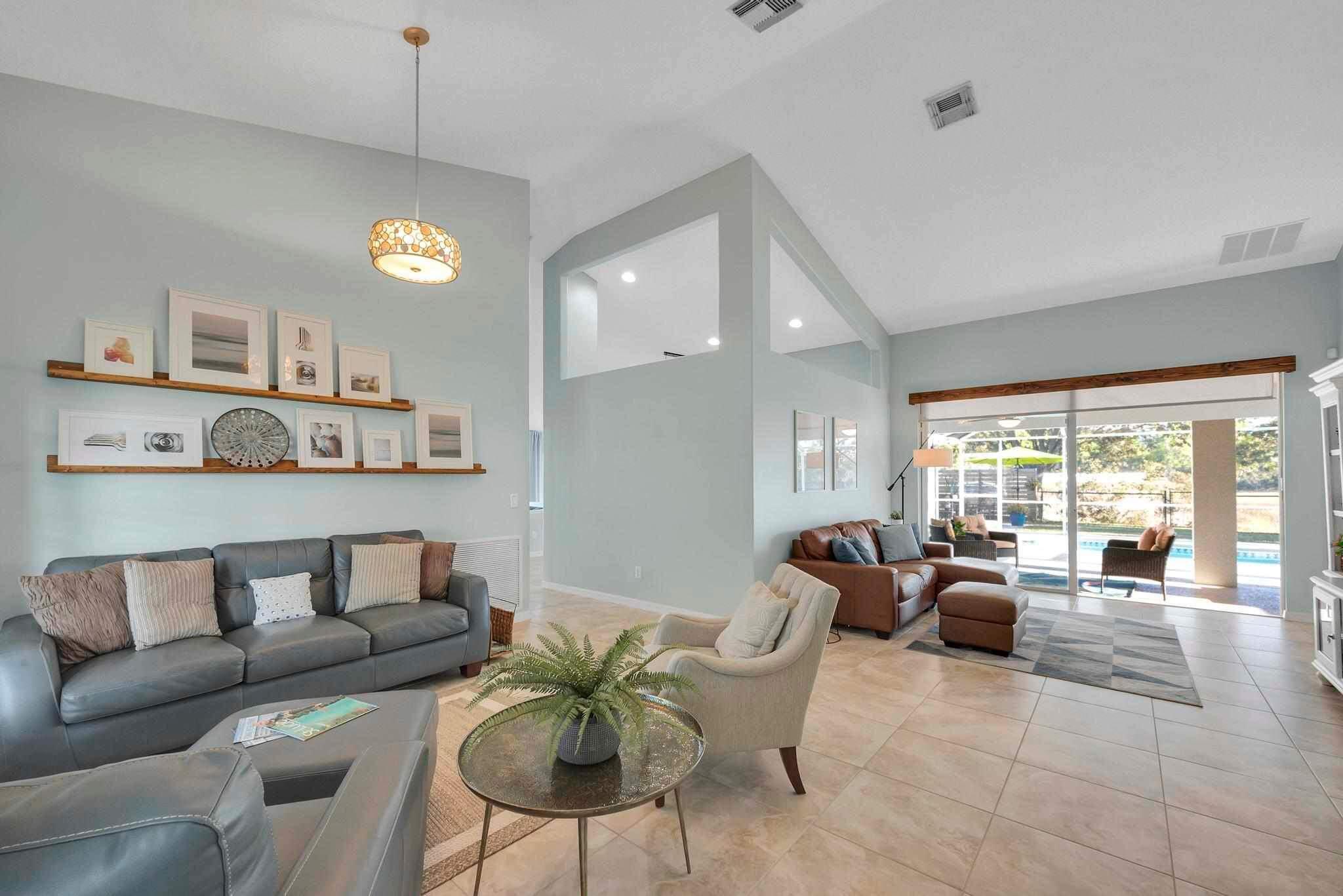 5464 Northwest Milner Drive Port St. Lucie, FL 34983 - Photo 6 of 49 a living room with furniture kitchen and a chandelier