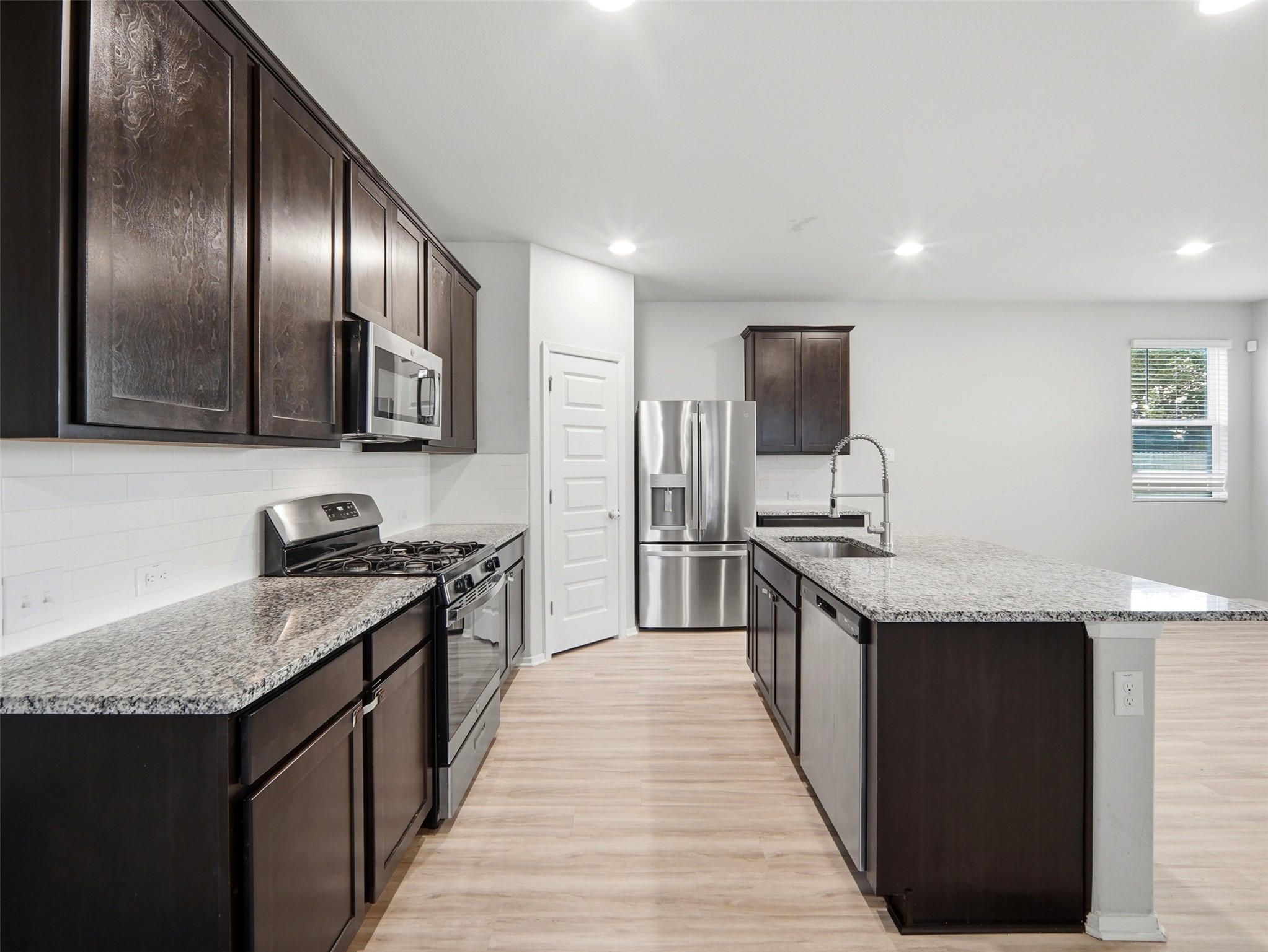 60 Bent Trl Lane Georgetown, TX 78628 - Photo 8 of 40 Modern kitchen with sleek dark cabinetry and granite countertops, ideal for culinary creations.