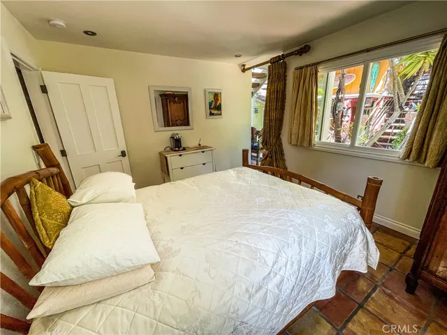 a bedroom with a bed a mirror and furniture