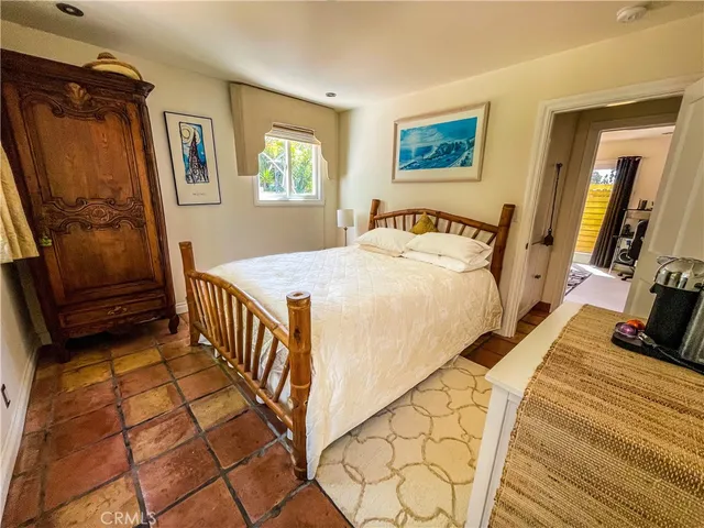 a bedroom with a bed a dresser next to a window