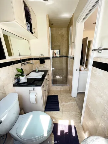 a bathroom with a granite countertop sink a toilet and shower