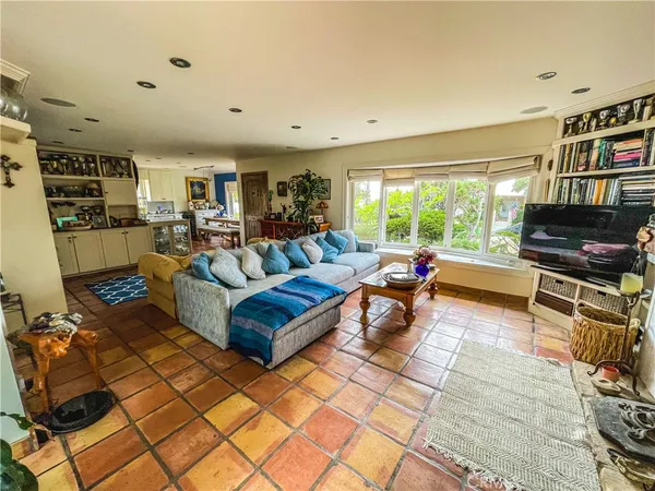 a living room with furniture a flat screen tv and a floor to ceiling window